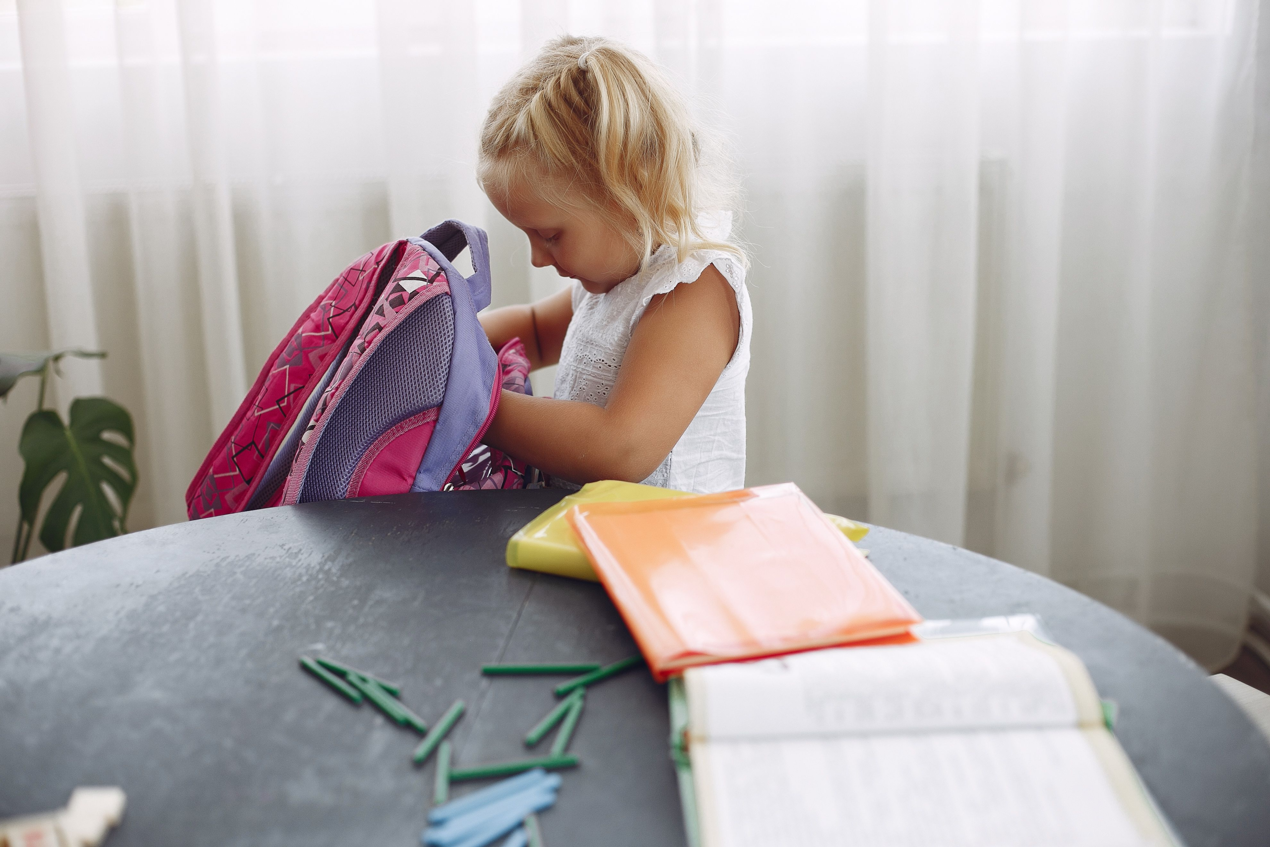 Niña preparando su mochila escolar